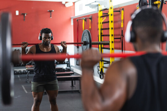 Fit African American man lifting weights at the gym