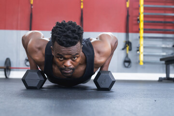 Fit African American man doing push-ups at the gym