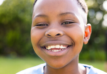 African American boy smiles brightly outdoors, unaltered