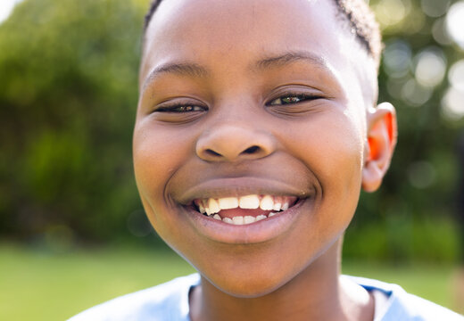 African American boy smiles brightly outdoors, unaltered
