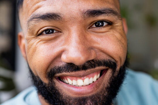 Close-up of a young biracial man smiling at the camera - Powered by Adobe