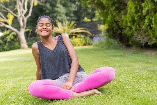 Teenage biracial girl enjoys a sunny day outdoors with ample copy space, unaltered