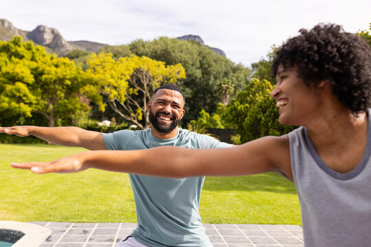 Biracial couple enjoys a fun moment outdoors doing yoga