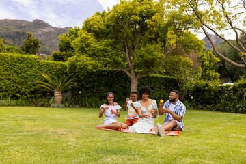 A young biracial family enjoys a picnic outdoors