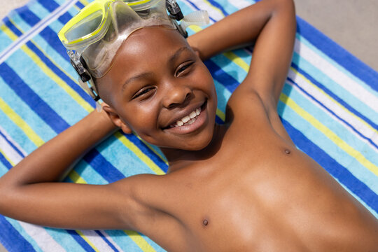 African American boy enjoys a sunny day poolside, with copy space
