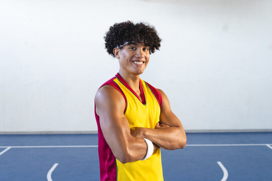 Young biracial man poses confidently on a basketball court