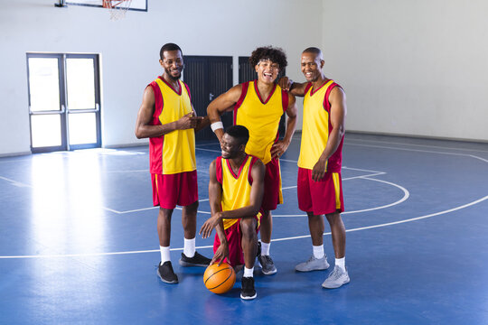 Diverse basketball players pose on the court