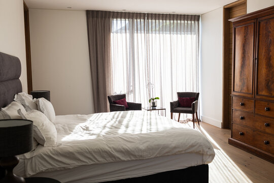 A neatly made bed dominates this bright bedroom setting