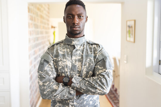 Portrait of serious african american male soldier standing with arms crossed at home, copy space