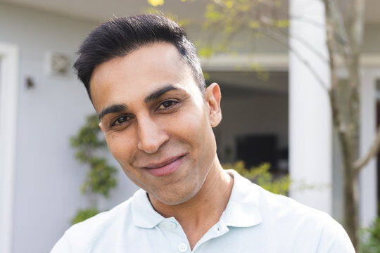 Middle Eastern man smiles warmly outdoors, unaltered