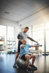 Ball, senior man and physiotherapist with band for resistance training, support or workout in retirement. Fitness, physiotherapy and elderly person with muscle stretching, mobility exercise or health