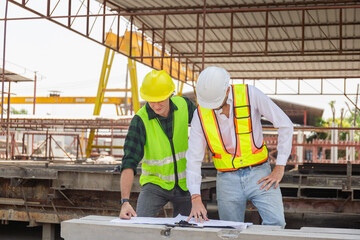 Engineer and foreman worker team with blueprints checking project at the precast concrete factory site, Engineer and builders in hardhats discussing on construction site