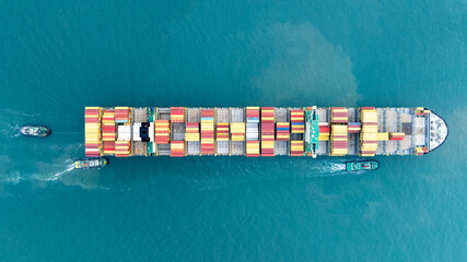 Cargo container ship carrying container and running in the ocean near international container port customs shipyard sea port concept smart logistic service. transportation logistics trading..