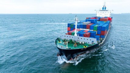 Front of Cargo container ship carrying container and running in the ocean near international...