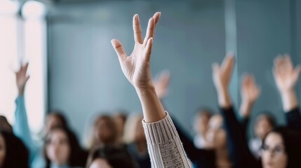 A close-up of a hand raised in a crowd of people, symbolizing participation, engagement, and active learning.