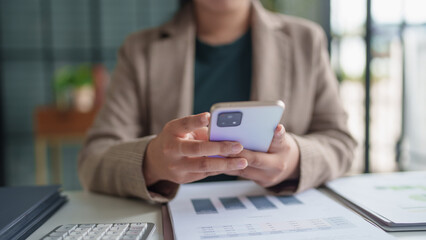 Asian Business woman using smart phone spending time checking news social media