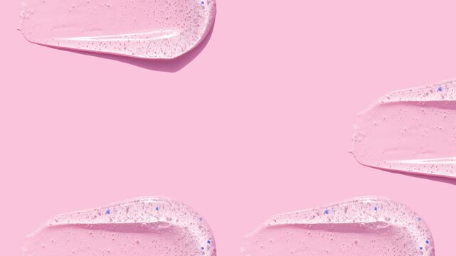 smears round drop of peeling gel test sample of scrub cosmetics on pink background