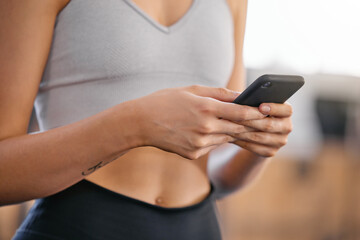 Hands, phone and woman in gym on fitness mobile app browsing for body building workout routine. Health, research and female athlete with cellphone for exercise tutorial online in sports center.