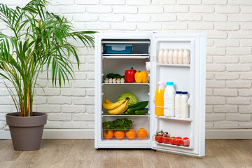 Open White Refrigerator With Fresh Produce In A Kitchen