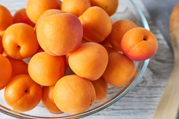 Ripe apricots in a plate on a table, top view.