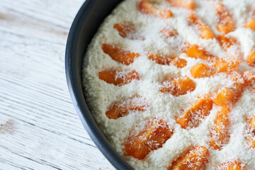 Apricot pie in baking mold, top view, copy space.