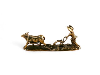 decorative statue of a person plowing a field with a cow on a white background