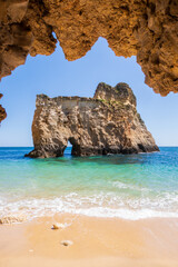 Fototapeta premium Small, heavenly beach vertically photographed from inside the rocks near Portimão, Algarve, Portugal