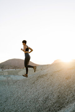 Runner woman training outdoors downhill.