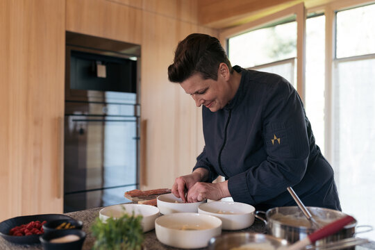 Chef preparing a gourmet dish in a kitchen with fresh ingredients