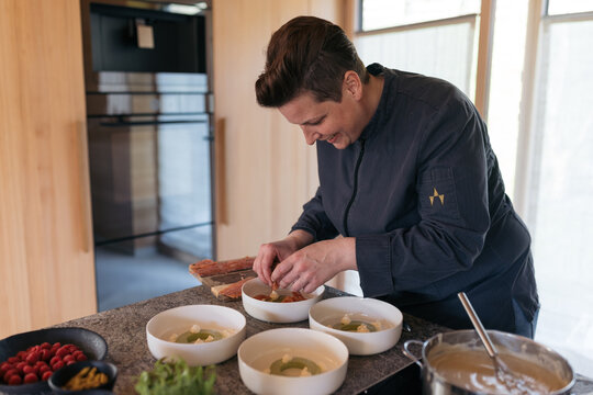 Chef preparing a gourmet dish in a kitchen with fresh ingredients