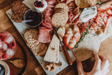 Charcuterie board with meats, cheeses, crackers, and fruits.