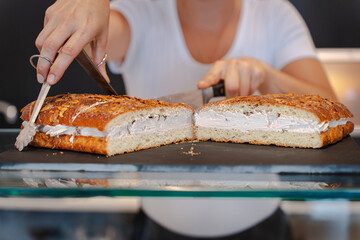 Unrecognizable woman baker picking up a piece of cake with her tongs
