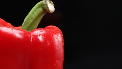Macrography of a red bell pepper against a sleek black background takes center stage. Each close-up...