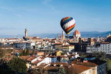 A large hot air balloon over the center of Florence. View of the renaissance capital from Piazza Michelangelo. Santa Maria del Fiore.