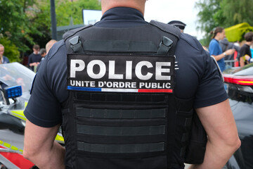 Bib of police, public order unit, on a policeman jacket.