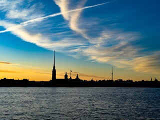 Stunning silhouette of St. Petersburg's skyline at sunset, featuring the Peter and Paul Fortress and other historic landmarks against a vibrant sky