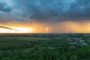 Obraz premium Golden hour light contrasts dark clouds over rural scene
