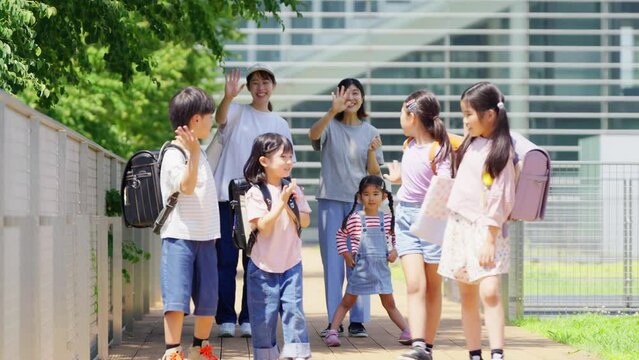 登校班の子供達を見送る母親