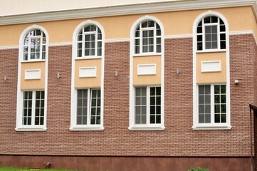 Part of the wall of a stone building with beautiful arched windows