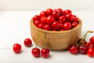Cherries. Fresh ripe cherries with leaves on a textured wooden background. Fresh sweet organic cherry pile. Berries and fruits. Vegan. Healthy eating. Place for text. Copy space