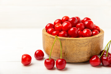 Cherries. Fresh ripe cherries with leaves on a textured wooden background. Fresh sweet organic cherry pile. Berries and fruits. Vegan. Healthy eating. Place for text. Copy space