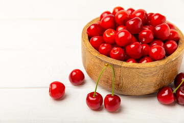 Cherries. Fresh ripe cherries with leaves on a textured wooden background. Fresh sweet organic cherry pile. Berries and fruits. Vegan. Healthy eating. Place for text. Copy space