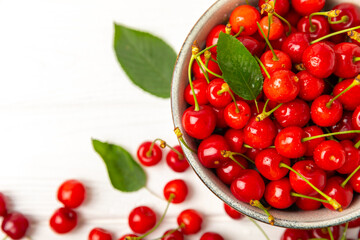 Cherries. Fresh ripe cherries with leaves on a textured wooden background. Fresh sweet organic cherry pile. Berries and fruits. Vegan. Healthy eating. Place for text. Copy space