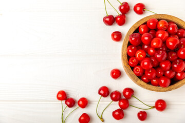 Cherries. Fresh ripe cherries with leaves on a textured wooden background. Fresh sweet organic cherry pile. Berries and fruits. Vegan. Healthy eating. Place for text. Copy space