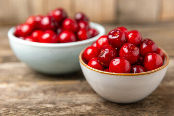 Cherries. Fresh ripe cherries with leaves on a textured wooden background. Fresh sweet organic cherry pile. Berries and fruits. Vegan. Healthy eating. Place for text. Copy space