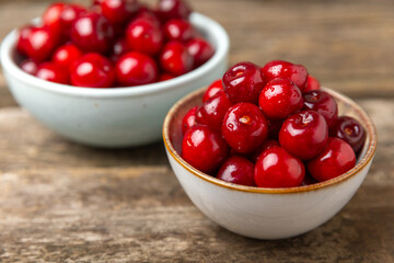 Cherries. Fresh ripe cherries with leaves on a textured wooden background. Fresh sweet organic cherry pile. Berries and fruits. Vegan. Healthy eating. Place for text. Copy space
