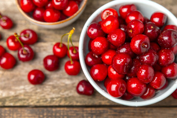 Cherries. Fresh ripe cherries with leaves on a textured wooden background. Fresh sweet organic cherry pile. Berries and fruits. Vegan. Healthy eating. Place for text. Copy space