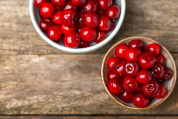 Cherries. Fresh ripe cherries with leaves on a textured wooden background. Fresh sweet organic cherry pile. Berries and fruits. Vegan. Healthy eating. Place for text. Copy space