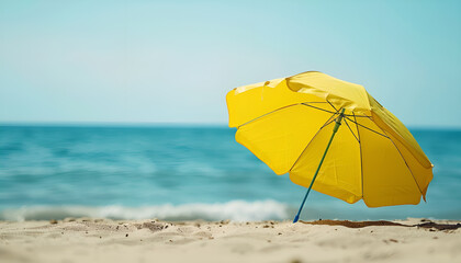 Yellow beach umbrella on sandy coast near ocean