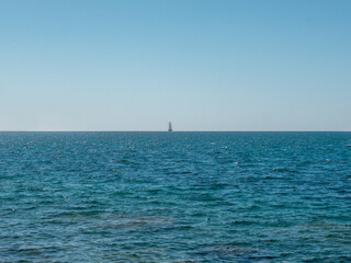Obraz premium Frigate on horizon line in open sea front view